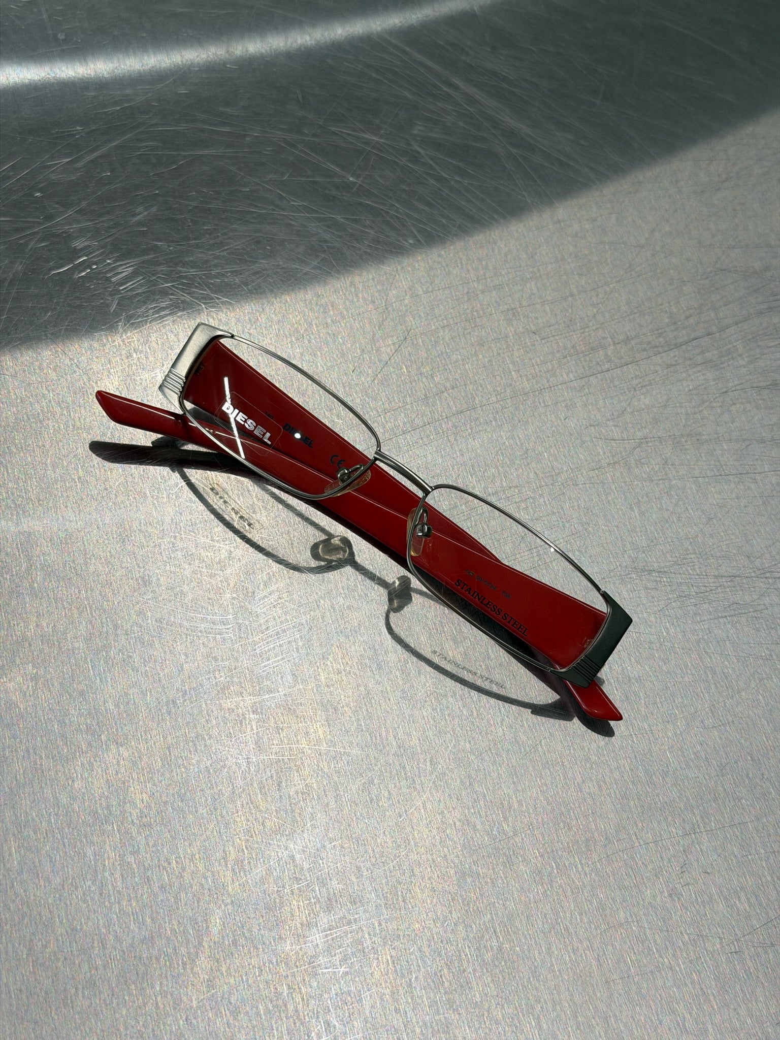 DIESEL SILVER GLASSES WITH RED TEMPLES AND CLASSIC DIESEL LOGO